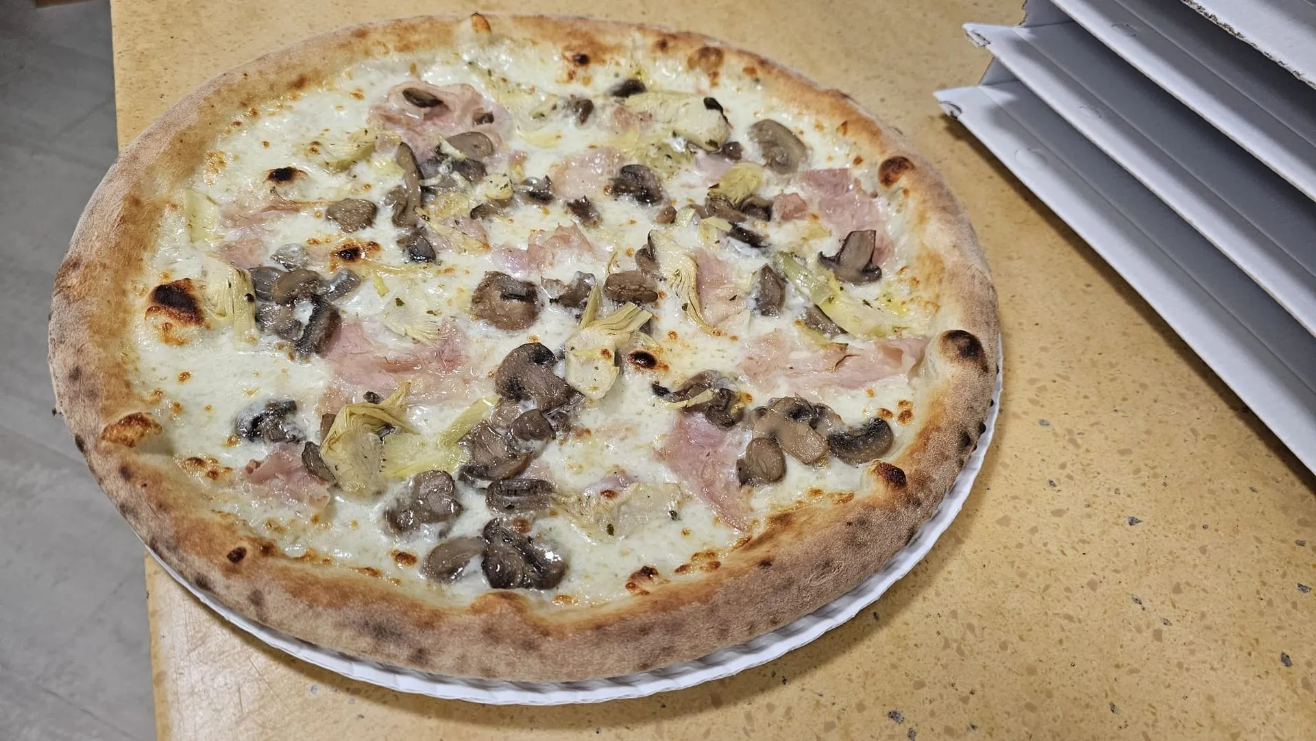 Pizza tonda con mozzarella e funghi